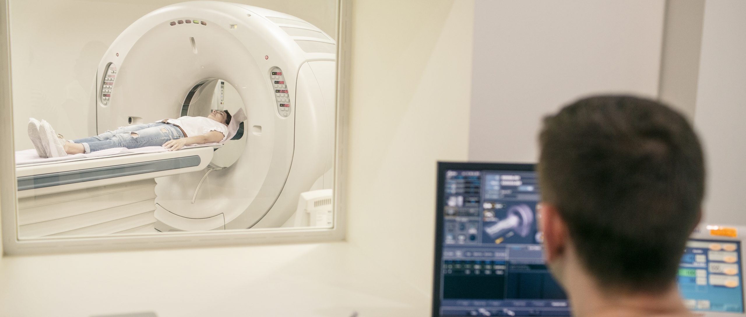 CT Technologist overlooking patient